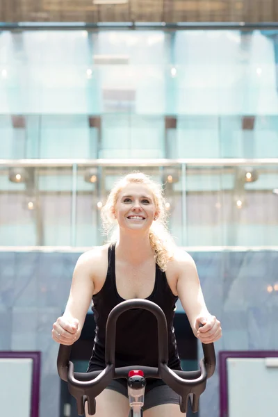 Young girl riding stationary bike — Stock Photo, Image