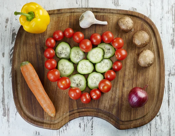 Hart teken gemaakt van cherry tomaten op het houten bord — Stockfoto