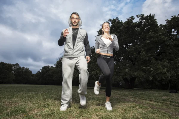Atractiva pareja joven corriendo en el parque —  Fotos de Stock