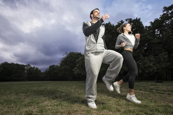 Atractiva pareja joven corriendo en el parque — Foto de Stock