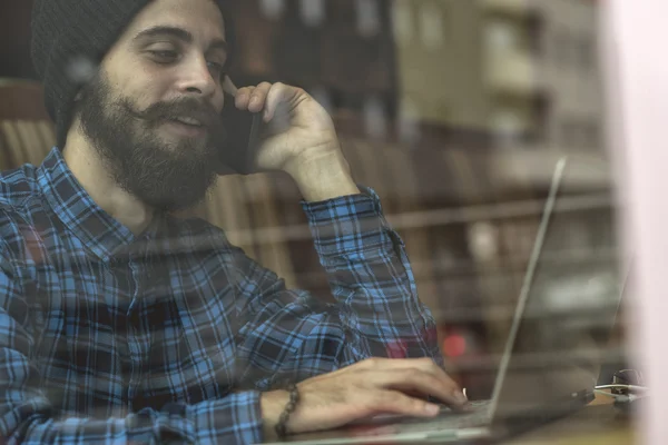 Jovem hipster homem trabalhando no laptop no café — Fotografia de Stock
