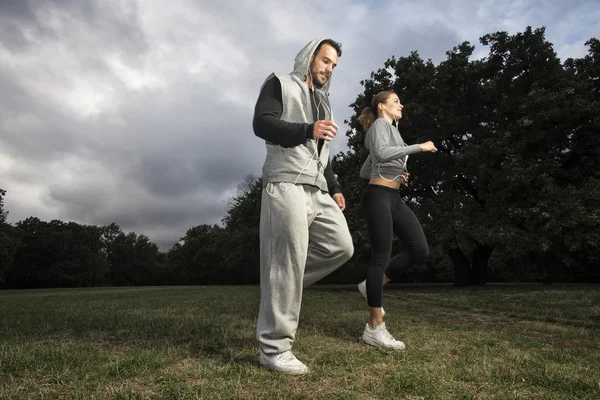 Atractiva pareja joven corriendo en el parque Fotos De Stock