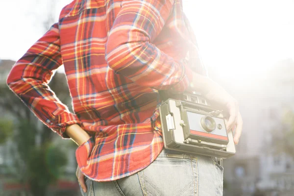 Young girl carrying old camera on her should outdoor — Stok Foto