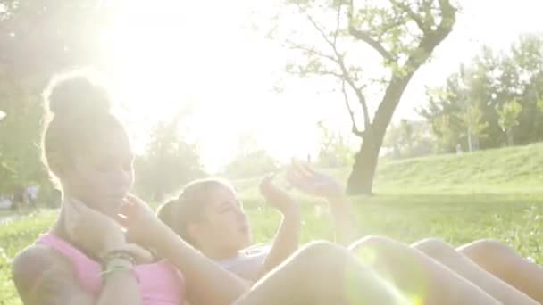 İşi iki genç kız parkta ups sit — Stok video