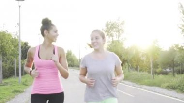 İki genç kız birlikte parkta koşu