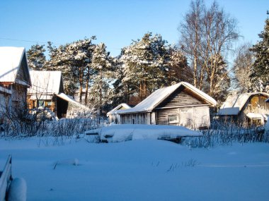 Küçük bir Karelian köyünde eski bir avlu. Hamamın manzarası orman ve komşuların binalarıyla dolu.
