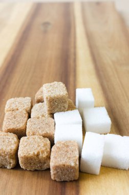Tahta masanın üzerinde beyaz ve kahverengi şeker küpü