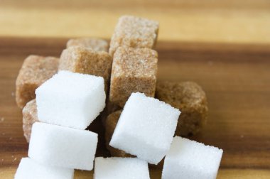 Tahta masanın üzerinde beyaz ve kahverengi şeker küpü