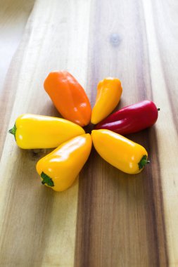 Mutfak tahtasındaki birkaç farklı renkte biber.