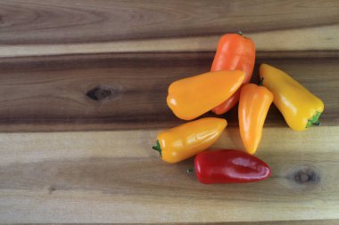 Mutfak tahtasındaki birkaç farklı renkte biber.