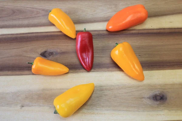 Mutfak tahtasındaki birkaç farklı renkte biber.