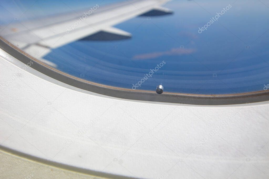 Hole in the window of the plane.Close up picture.