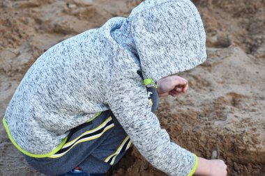 Yazın kumda oynayan bir çocuğun silueti.