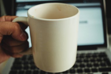 Bilgisayarın önünde bir fincan kahve.