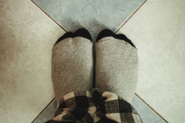 Döşemede çoraplı çıplak ayaklar.