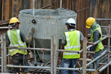 Beton yığını kap formu çalışma içine dökme inşaat işçilerin bir grup
