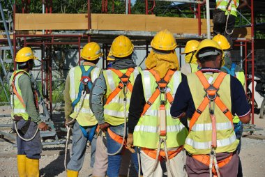Grup inşaat işçileri montajı açık alan.  