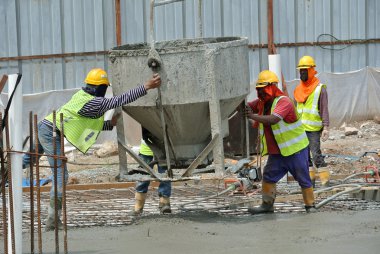 Bir grup inşaat işçileri beton zemin döşeme formu çalışma içine dökme