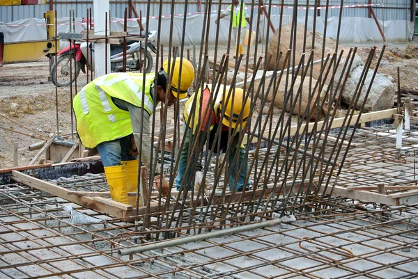 Two construction workers fabricating ground beam steel reinforcement bar — Stock Photo, Image