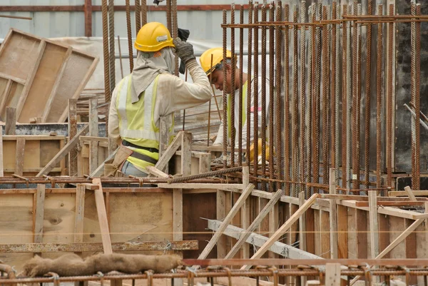 Два рабочих-строителя изготавливают арматуру из стали — стоковое фото