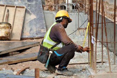 İnşaat İşçileri şantiyede beton duvar için çelik takviye imal.