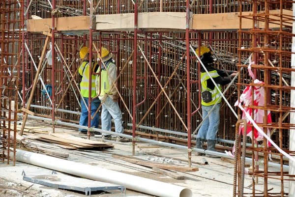 Trabalhadores da construção civil fabricam reforço de aço para parede de concreto no canteiro de obras . — Fotografia de Stock