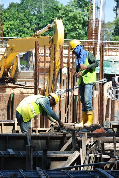 Grupo de trabalhadores da construção civil fabricando barra de reforço de coluna — Fotografia de Stock