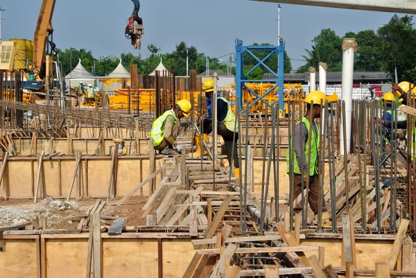 Grupo de trabalhadores da construção civil fabricando barra de reforço de aço — Fotografia de Stock