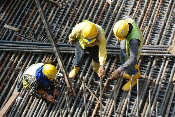 Gruppe von Bauarbeitern, die Stahlbewehrungsstangen herstellen — Stockfoto