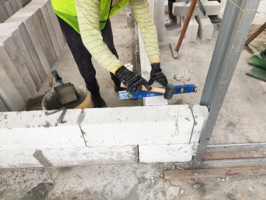 SEREMBAN, MALAYSIA - 16 Mart 2020: İnşaat işçileri inşaat alanında otoklasik beton blok döşüyorlar. Bu materyalin kullanımı zaman kazandırabilir ve inşaat işini kolaylaştırabilir.