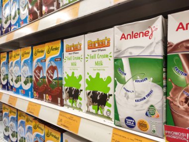 SEREMBAN, MALAYSIA - 6 Temmuz 2019: İşlenmiş ve taze süt kağıt kutuda paketlenmiş ve süpermarketlerin içindeki raflarda sergilenmektedir. Markaya göre sıralanır ve müşterinin seçmesi kolay olur.. 