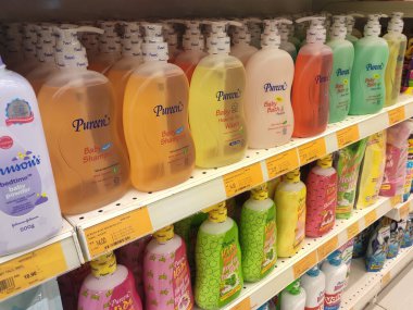 Şampuan ve bebek banyosu plastik şişe ambalajında ve satış rafında satışta. Markaya göre sıralanır ve bir fiyat etiketi konur.