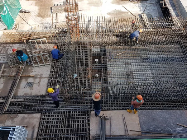 Shah Alam Malaysia 2020年3月23日 建設現場で鉄鋼強化バーを製造する建設労働者 彼らはそれを木の形を使用してカバーアップする前に小さなワイヤを使用して接続しました — ストック写真