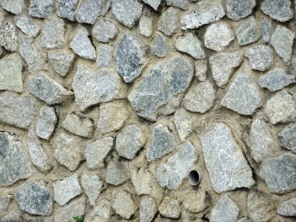 Stone rubble wall. Used as retaining wall. The stone bond together using cement mortar and adhesive.