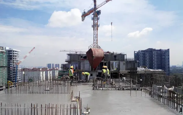 Malacca Malaysia 2017年3月9日 タワークレーンで運搬したコンクリートバケツを用いてコンクリートを打設し 建設現場の木材加工に注ぐ建設労働者のグループ — ストック写真