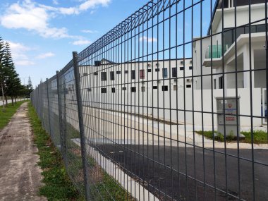 MELAKA, MALAYSIA -5 Haziran 2020: Davetsiz misafirden korunmak için çevredeki veya mülkiyet sınırındaki galvanize demir yükünden yapılan tırmanma karşıtı çit. Kapalı ağları davetsiz misafirlerin çitlere tırmanmasını engelleyebilir..