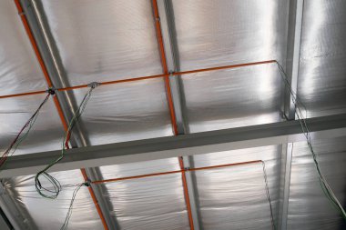 KLANG, MALAYSIA - 6 Mart 2020: Tavanın üzerinde elektrik şebekesi, kanal ve kablolar. Çatı kirişlerine bir elektrikçi yerleştirin.