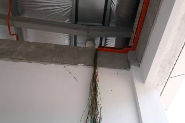 KLANG, MALAYSIA - 6 Mart 2020: Tavanın üzerinde elektrik şebekesi, kanal ve kablolar. Çatı kirişlerine bir elektrikçi yerleştirin.