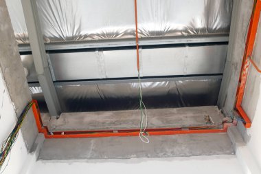 KLANG, MALAYSIA - 6 Mart 2020: Tavanın üzerinde elektrik şebekesi, kanal ve kablolar. Çatı kirişlerine bir elektrikçi yerleştirin.