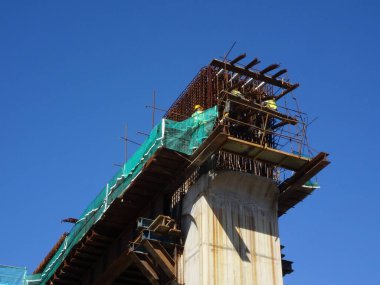 MALACCA, MALAYSIA - 14 Mart 2020: İnşaat işçileri inşaat alanında yükseklerde çalışıyor. Kaza yapmalarını önlemek için onlara emniyet kemeri ve diğer güvenlik ekipmanları sağlanıyor..