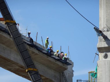 MALACCA, MALAYSIA - 14 Mart 2020: İnşaat işçileri inşaat alanında yükseklerde çalışıyor. Kaza yapmalarını önlemek için onlara emniyet kemeri ve diğer güvenlik ekipmanları sağlanıyor..