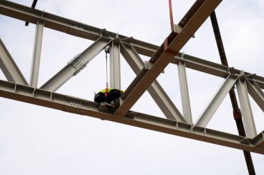 MALACCA, MALAYSIA - 14 Mart 2020: İnşaat işçileri inşaat alanında yükseklerde çalışıyor. Kaza yapmalarını önlemek için onlara emniyet kemeri ve diğer güvenlik ekipmanları sağlanıyor..