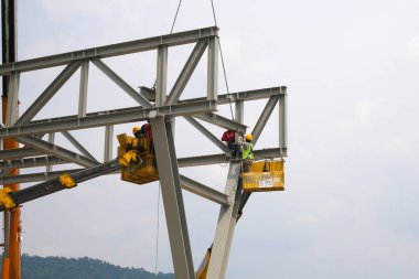 MALACCA, MALAYSIA - 14 Mart 2020: İnşaat işçileri inşaat alanında yükseklerde çalışıyor. Kaza yapmalarını önlemek için onlara emniyet kemeri ve diğer güvenlik ekipmanları sağlanıyor..
