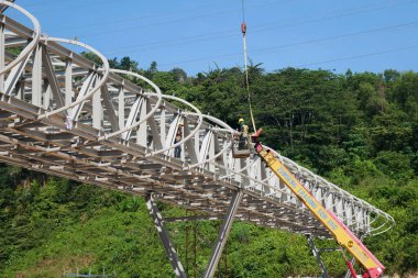 MALACCA, MALAYSIA - 14 Mart 2020: İnşaat işçileri inşaat alanında yükseklerde çalışıyor. Kaza yapmalarını önlemek için onlara emniyet kemeri ve diğer güvenlik ekipmanları sağlanıyor..