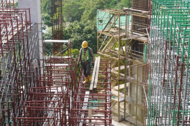 MALACCA, MALAYSIA - 14 Mart 2020: İnşaat işçileri inşaat alanında yükseklerde çalışıyor. Kaza yapmalarını önlemek için onlara emniyet kemeri ve diğer güvenlik ekipmanları sağlanıyor..