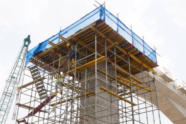 MALACCA, MALAYSIA - 14 Mart 2020: İnşaat işçileri inşaat alanında yükseklerde çalışıyor. Kaza yapmalarını önlemek için onlara emniyet kemeri ve diğer güvenlik ekipmanları sağlanıyor..