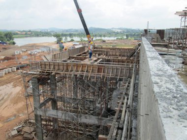 KUALA LUMPUR, MALAYSIA - 16 Temmuz 2017: Marangozlar inşaat alanında kereste ve kontrplak formları üretirler. Güçlendirilmiş beton yapının kalıbı olarak ahşap biçimlendirme.