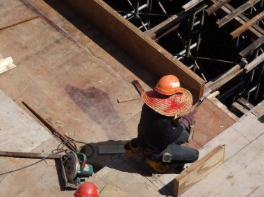 KUALA LUMPUR, MALAYSIA - 16 Temmuz 2017: Marangozlar inşaat alanında kereste ve kontrplak formları üretirler. Güçlendirilmiş beton yapının kalıbı olarak ahşap biçimlendirme.