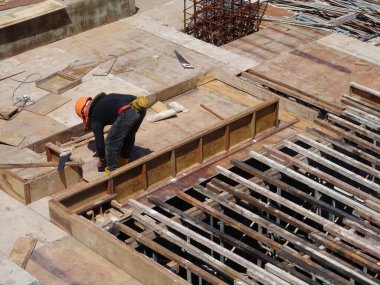 KUALA LUMPUR, MALAYSIA - 16 Temmuz 2017: Marangozlar inşaat alanında kereste ve kontrplak formları üretirler. Güçlendirilmiş beton yapının kalıbı olarak ahşap biçimlendirme.