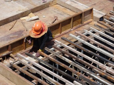 KUALA LUMPUR, MALAYSIA - 16 Temmuz 2017: Marangozlar inşaat alanında kereste ve kontrplak formları üretirler. Güçlendirilmiş beton yapının kalıbı olarak ahşap biçimlendirme.